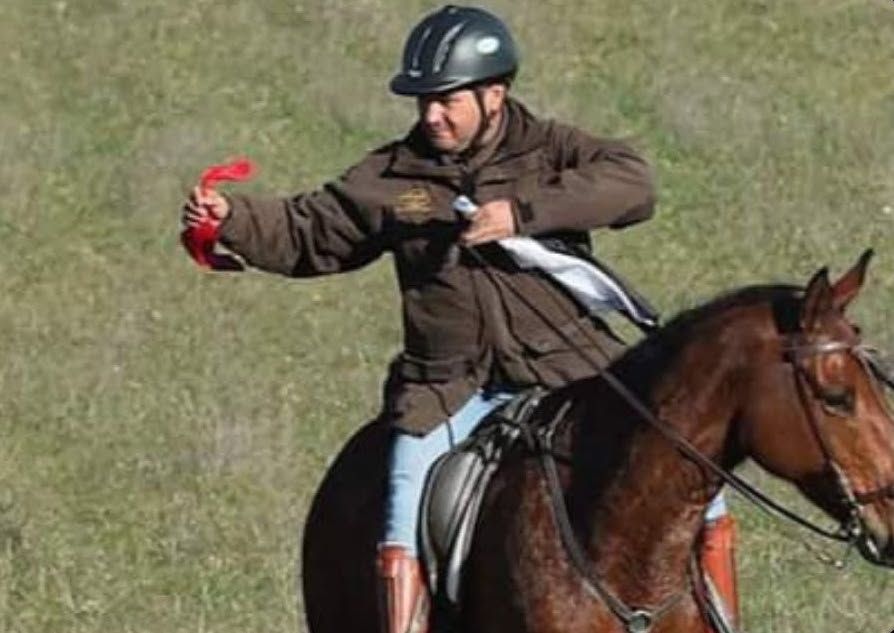 Juez lleva en mano izquierda los pañuelos negro y blanco del collar del galgo descalificado y en su mano derecha el pañuelo rojo del galgo vencedor